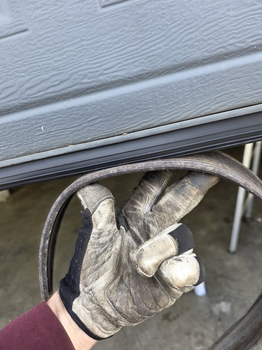 Worn garage door bottom seal next to the new replacement seal