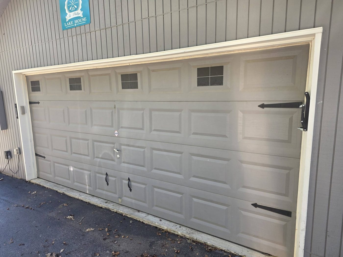 Old beige carriage-style garage door before replacement