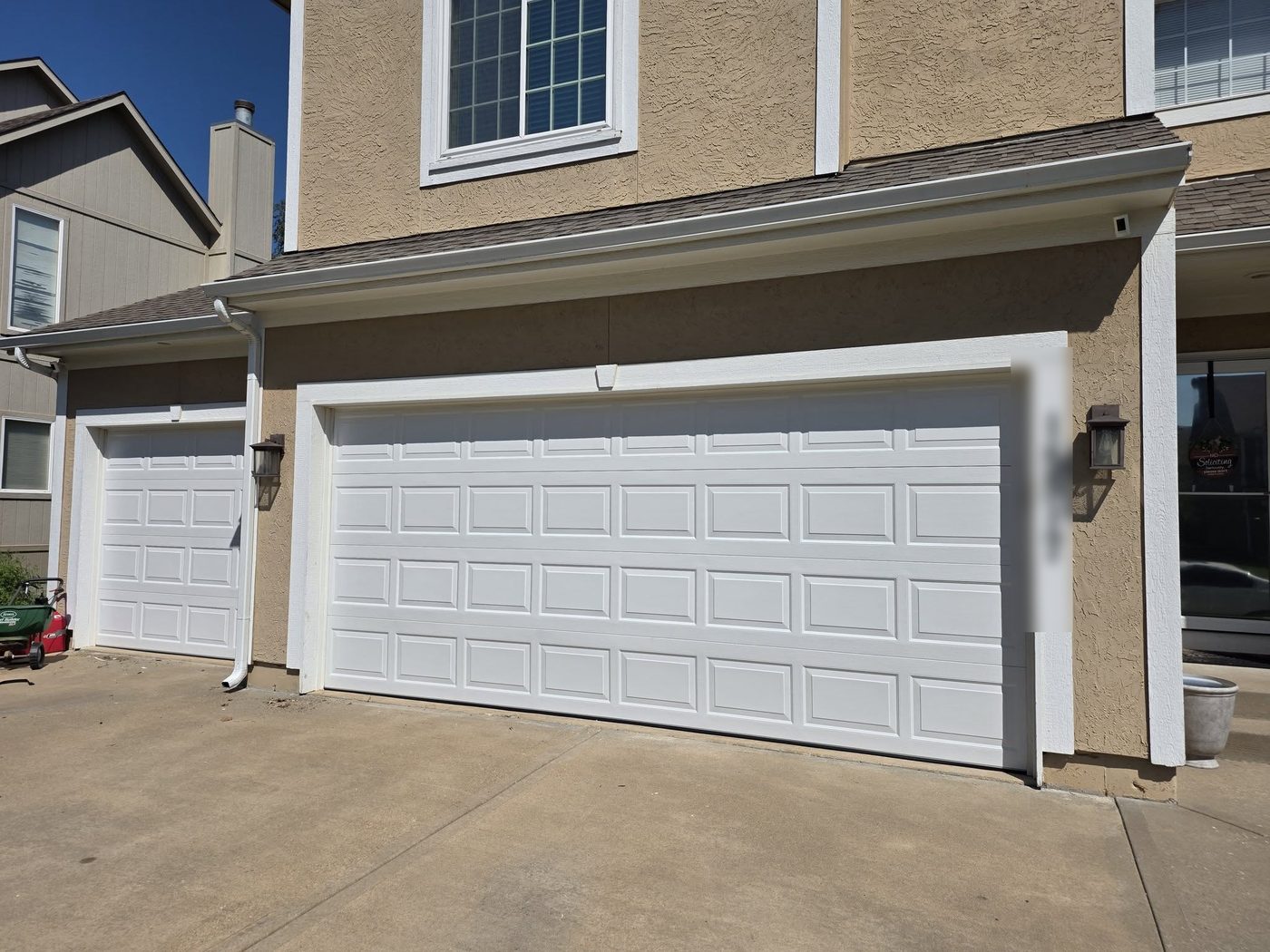 White raised-panel doors on a three-car garage